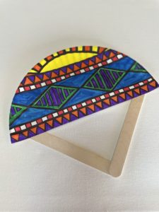 Paper plate fan art with popsicle sticks as frames and colorful fan