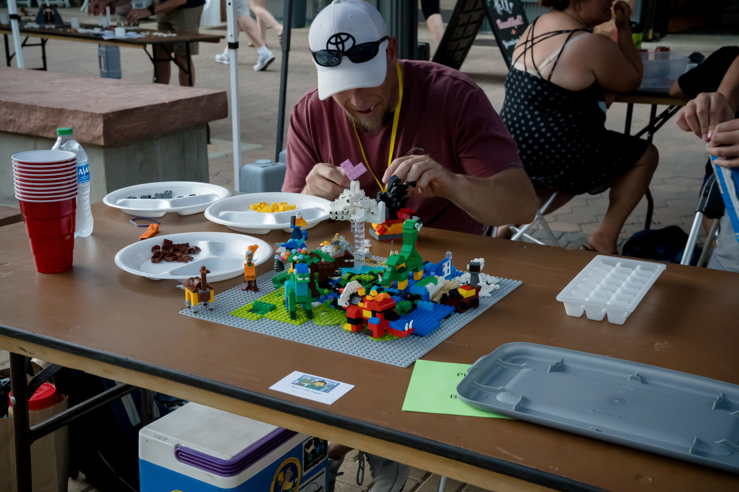 Adult building a dinosaur scene for the LEGO® Creation Festival