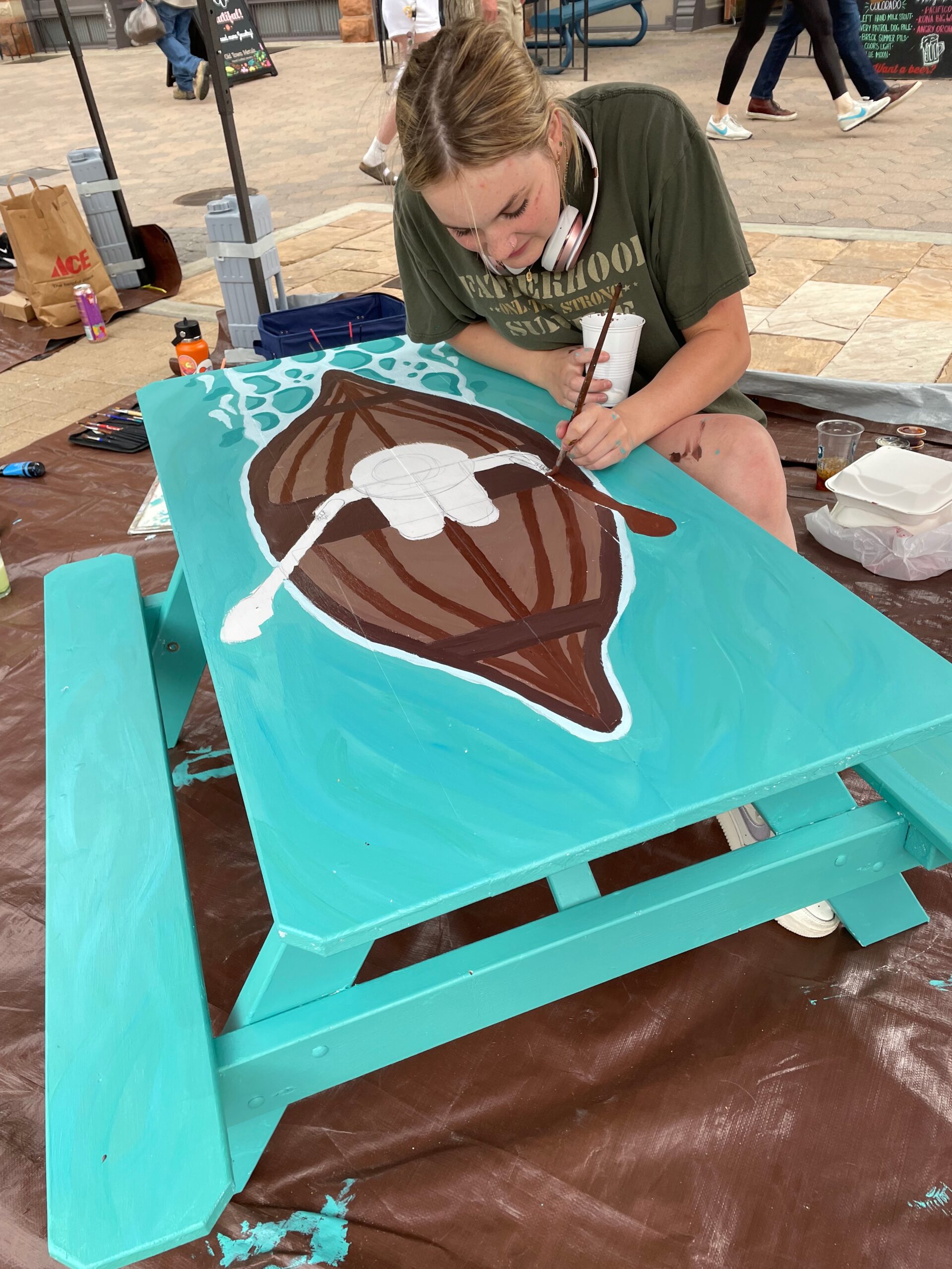 woman painting Adirondack table
