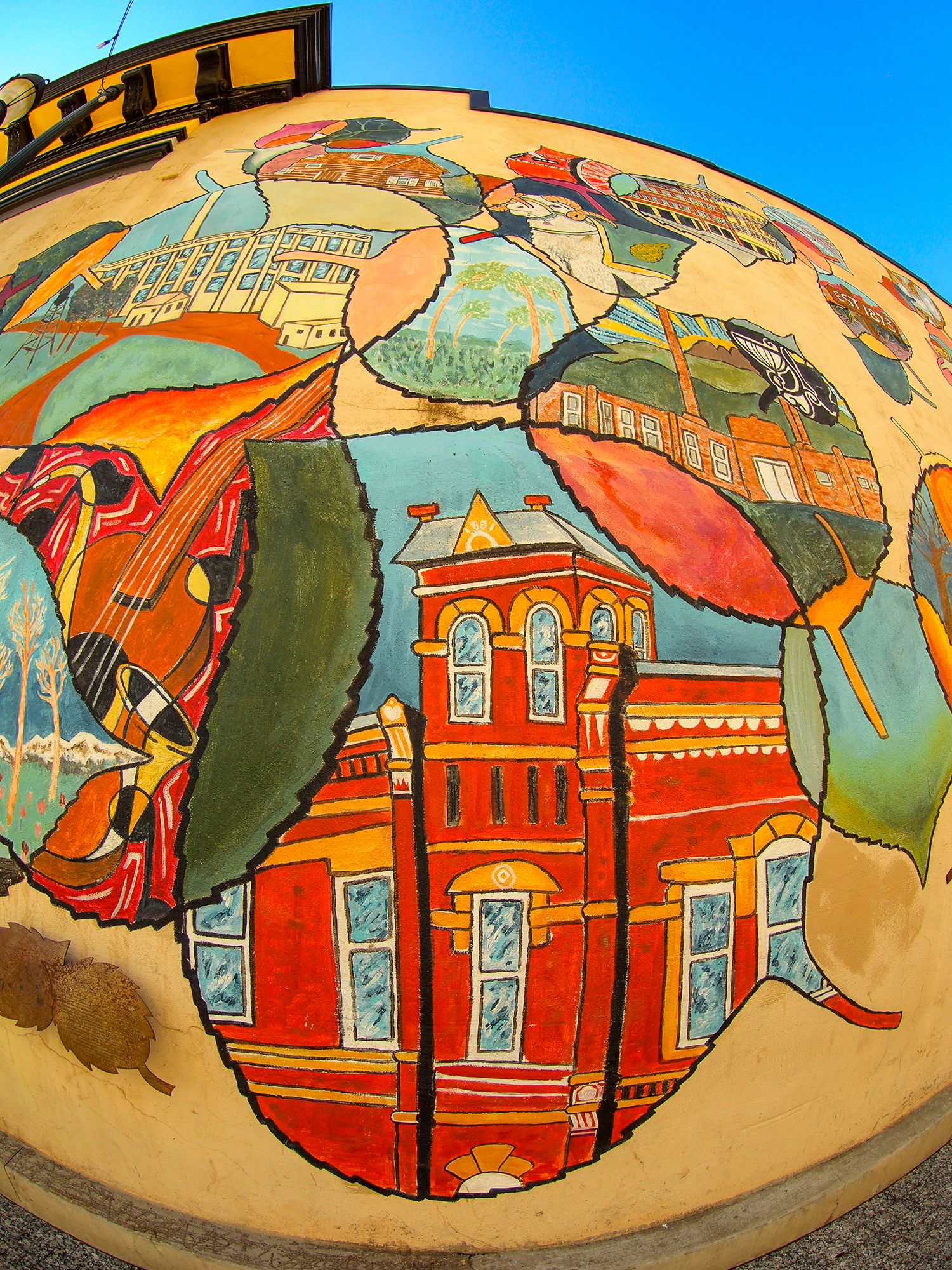 A fish-eye picture of a painted mural of downtown buildings and iconic Fort Collins' features