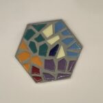 A mosaic tiles with blue, white, purple, green, orange and yellow mosaic pieces cemented in a single tile