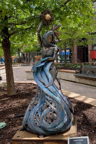 Sculpture, Colorful Steel, figure holding sun, swirl shapes at base