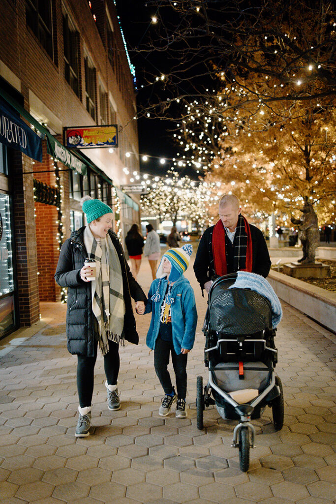 Family walking under the downtown fort collins holiday lights